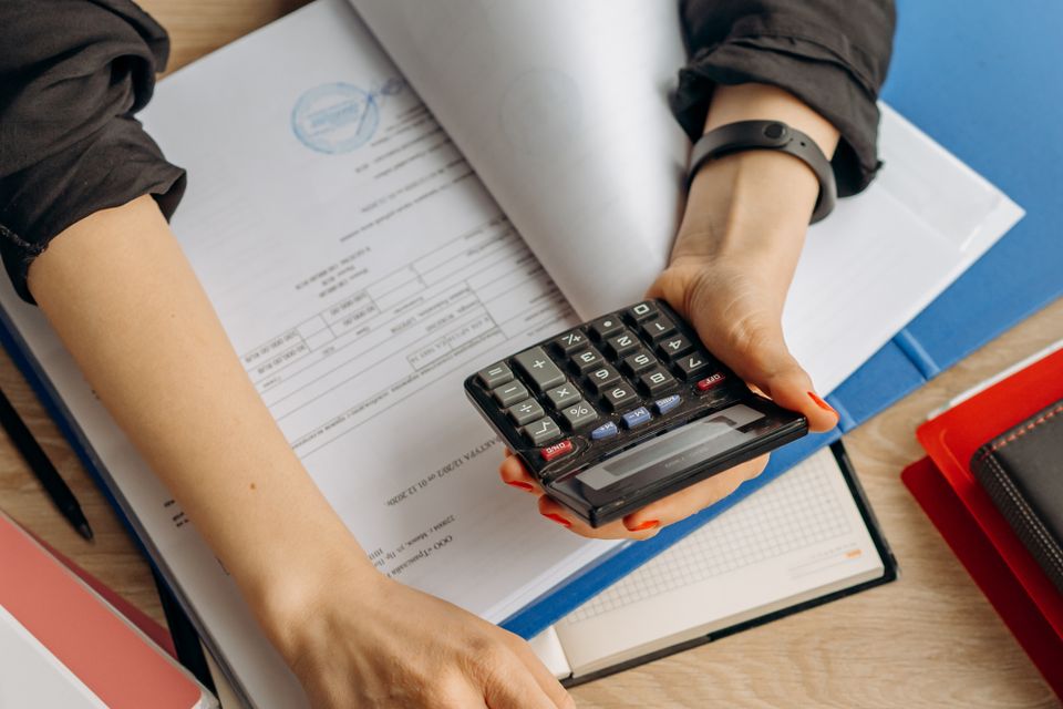Taschenrechner und Unterlagen bei der Berechnung des GKV-Ehepartner-Zuschlags und der Beitragsbemessungsgrenze ab 2027