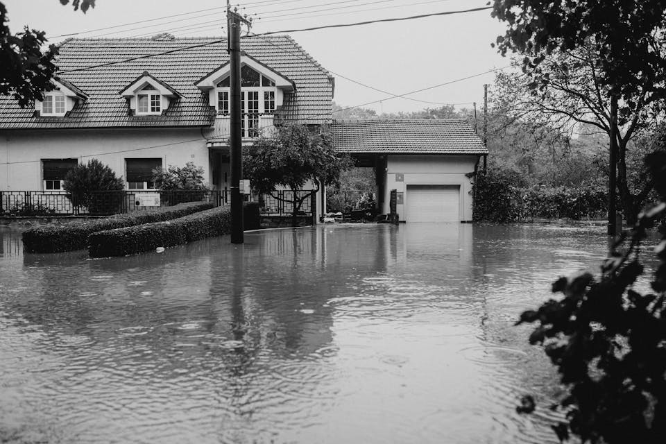 Überflutete Straße vor einem Wohnhaus nach Starkregen